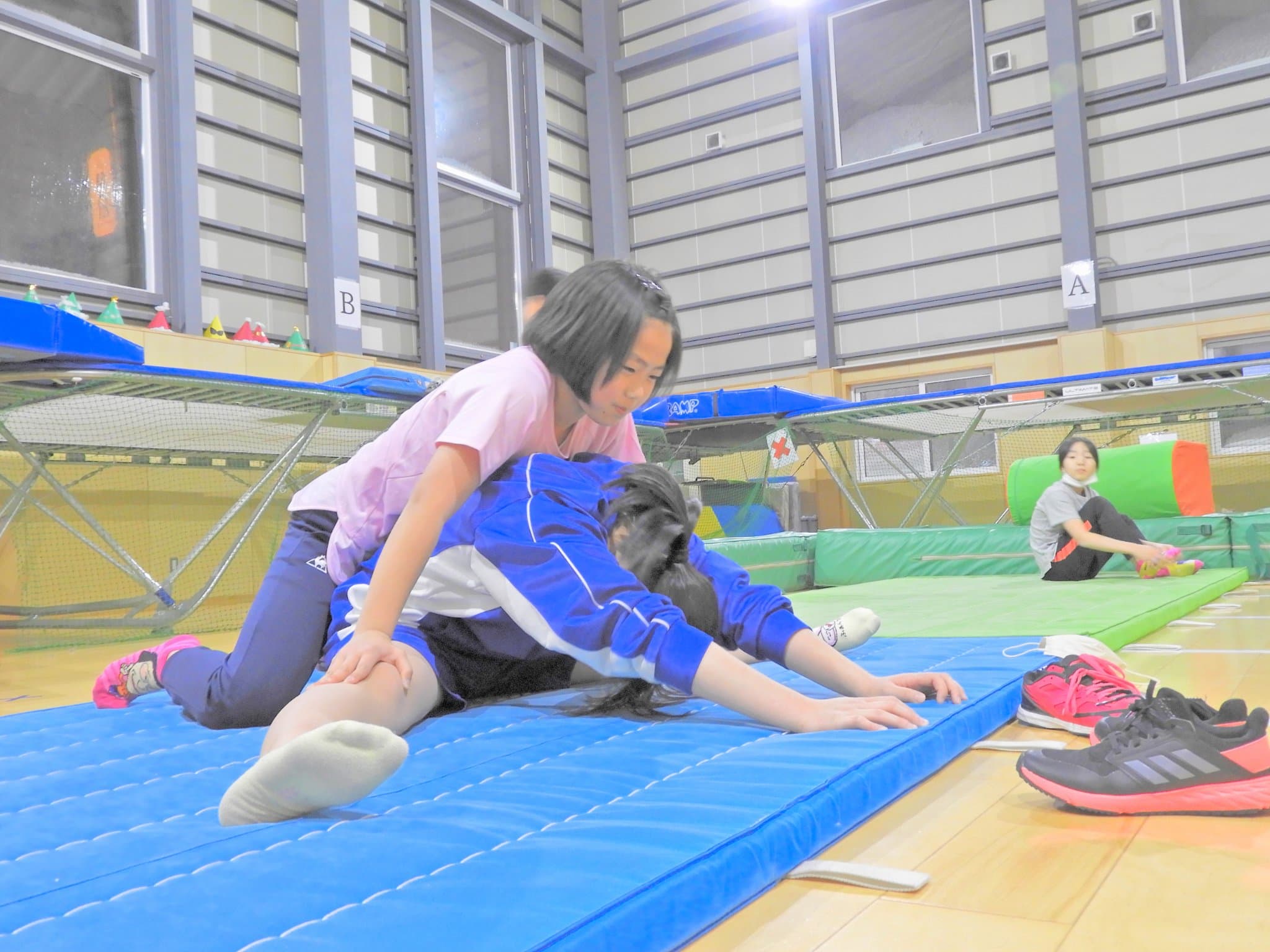 体育館でストレッチをする子どもたち